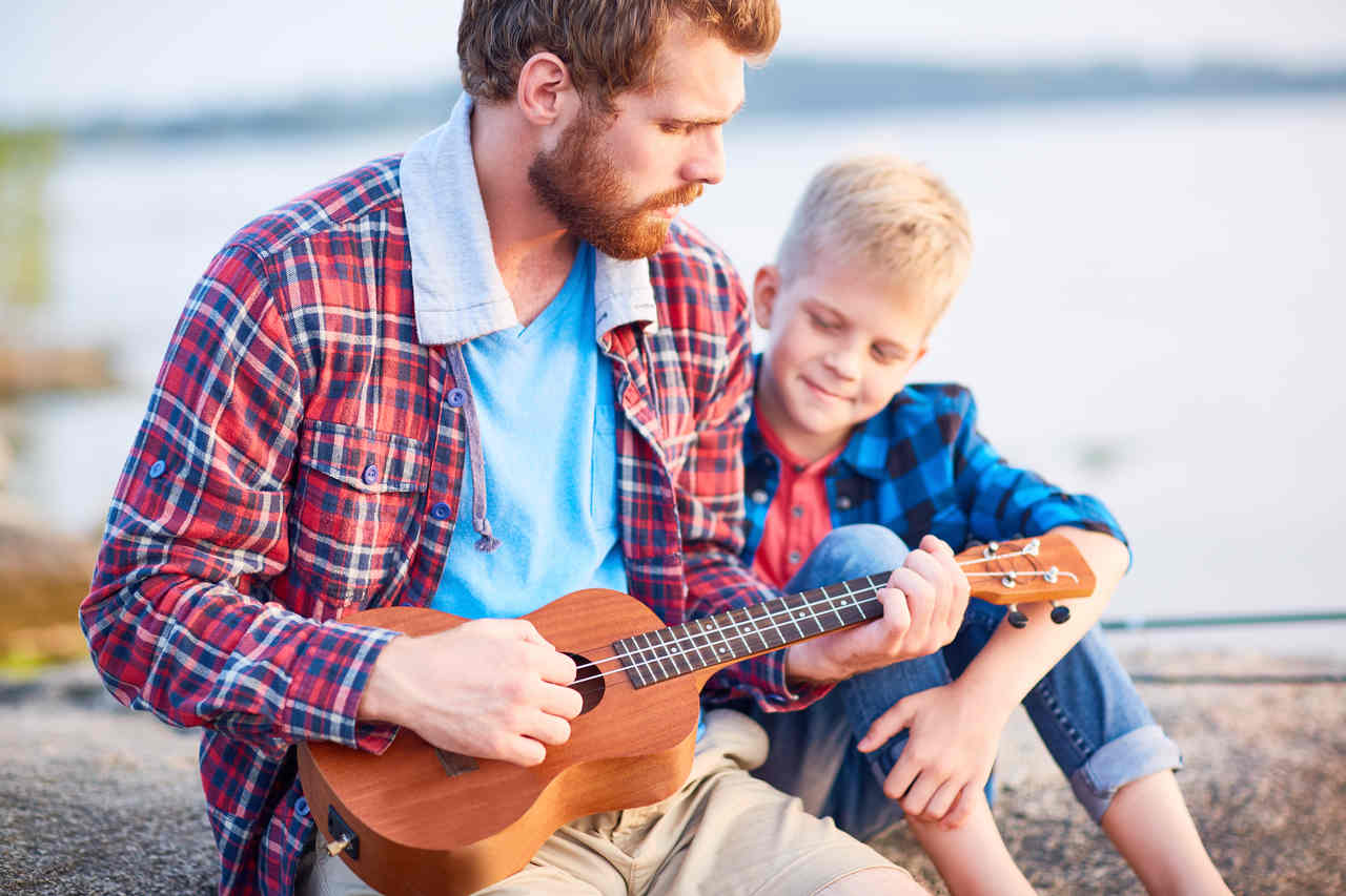 oğluyla birlikte ukulele çalan bir baba
